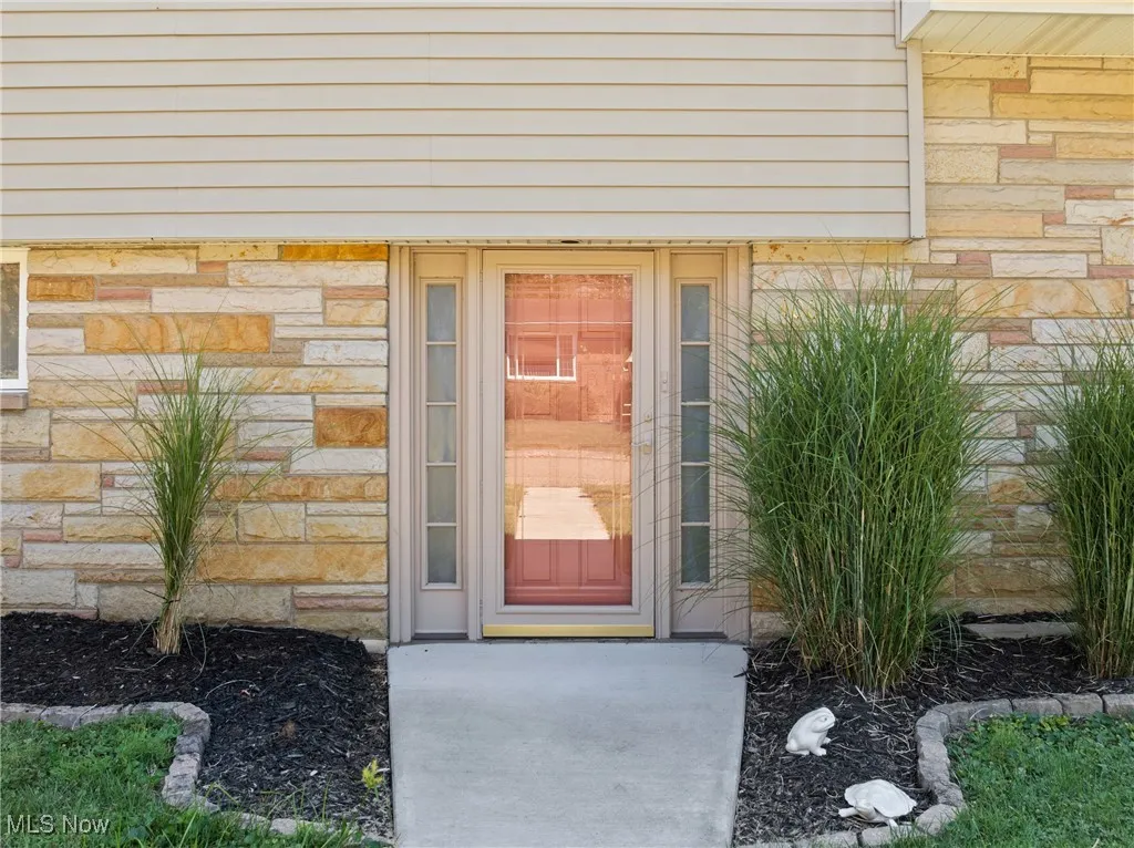 Entrance to property featuring stone siding