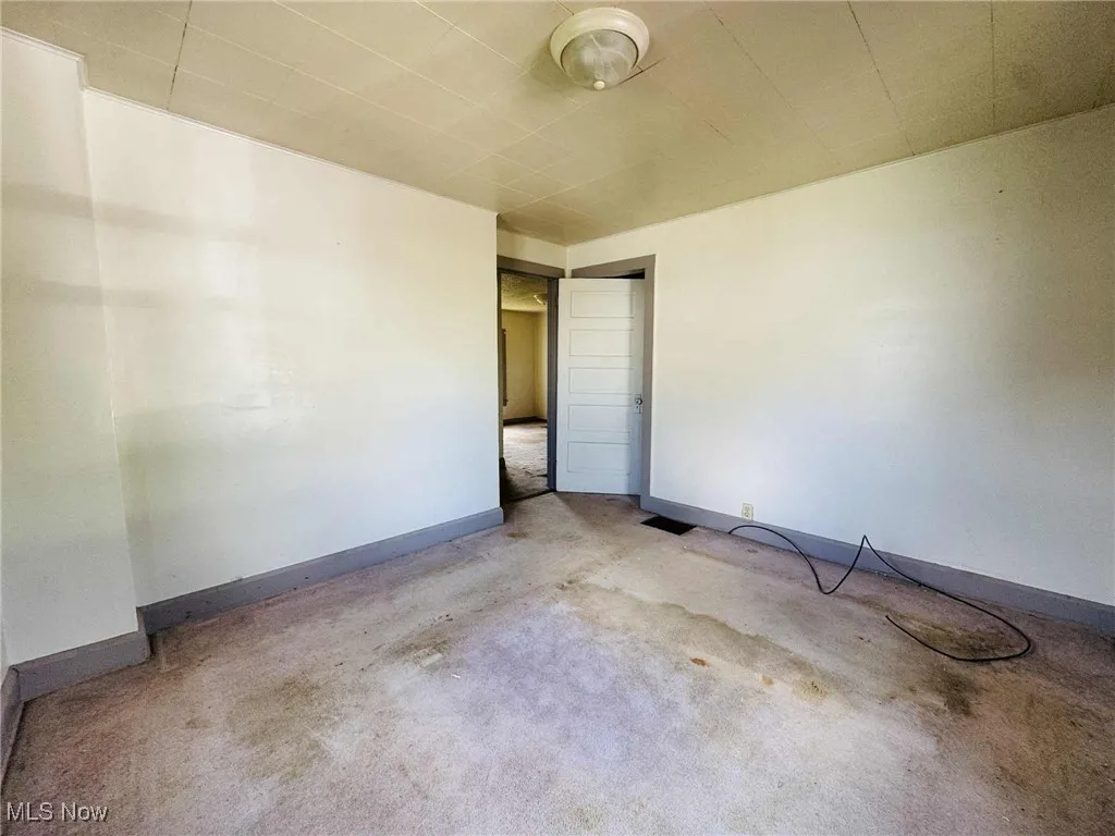 Carpeted spare room with baseboards