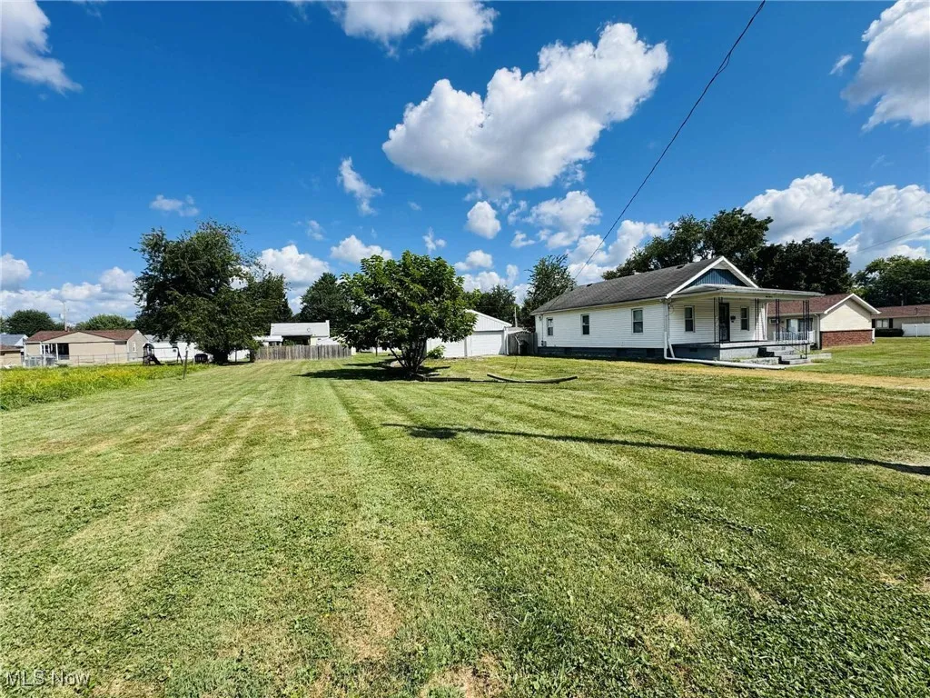 View of green lawn featuring a porch