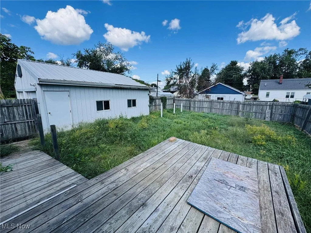 Wooden deck with a fenced backyard and an outdoor structure