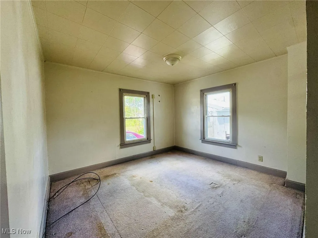 Carpeted spare room with baseboards
