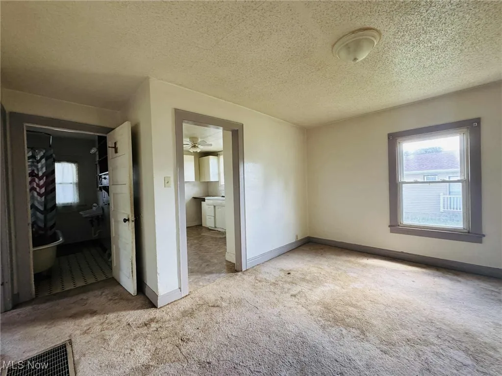 Unfurnished bedroom featuring carpet floors and a textured ceiling