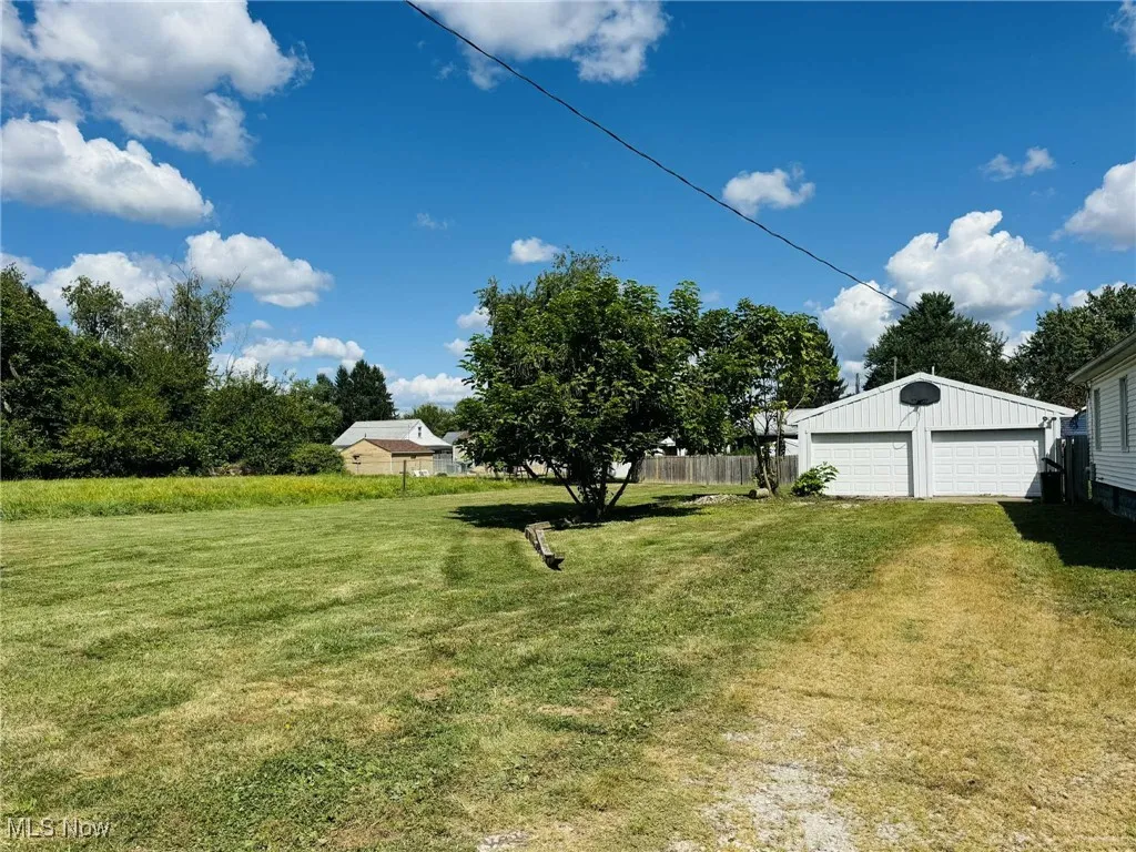View of yard with a detached garage and an outdoor structure