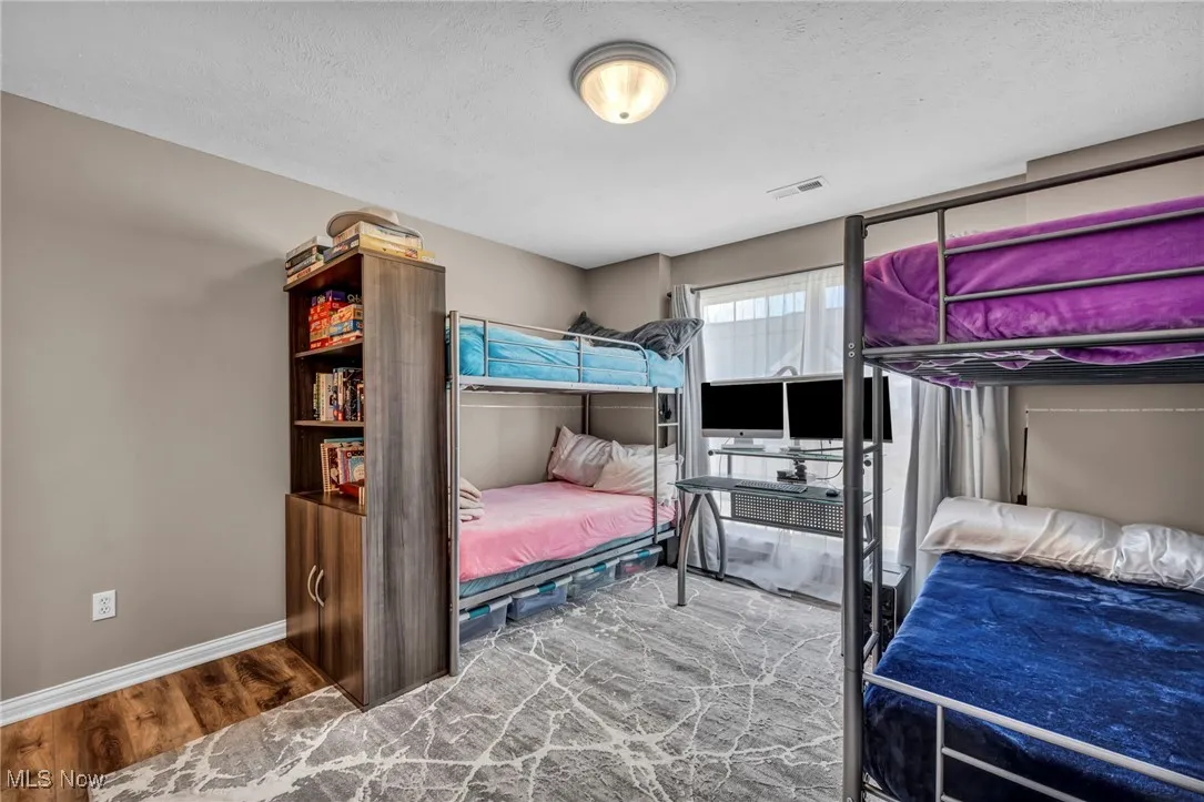 Bedroom with wood finished floors and a textured ceiling