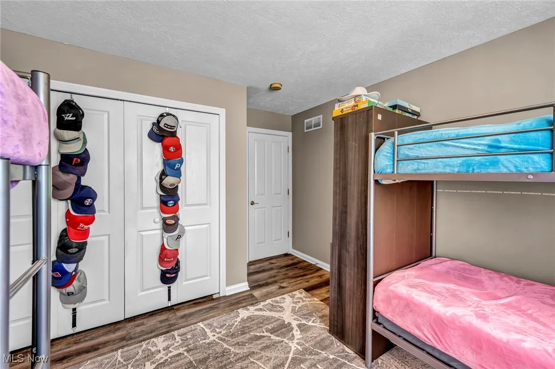 Bedroom with a textured ceiling,  and a large  closet