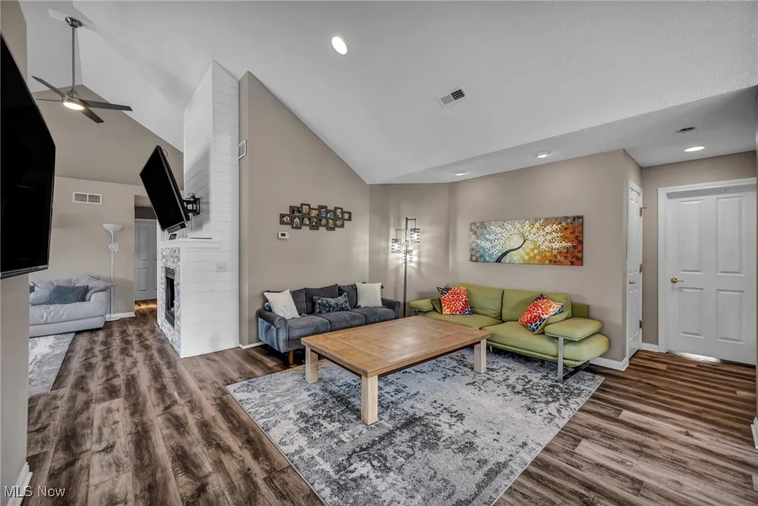 Living area featuring a large fireplace,  high vaulted ceiling, a ceiling fan, and recessed lighting