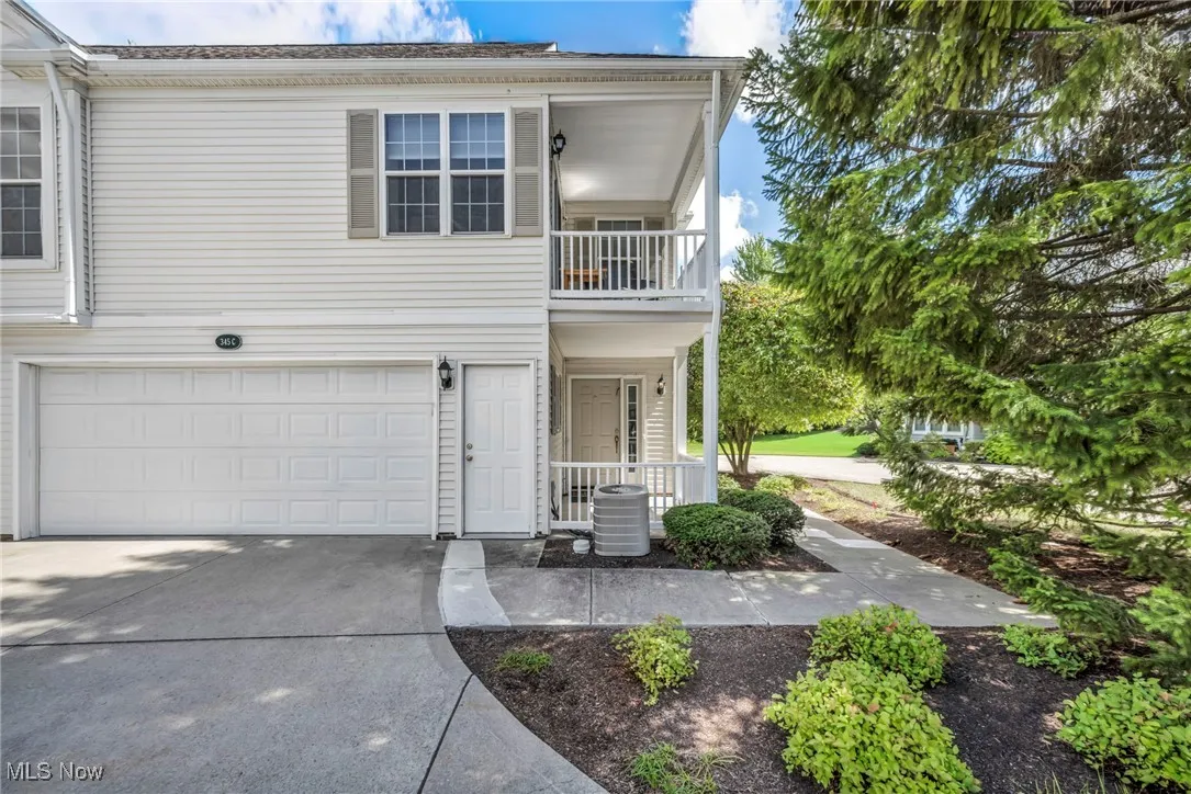 Front of home with  a 2 car  garage, and a balcony