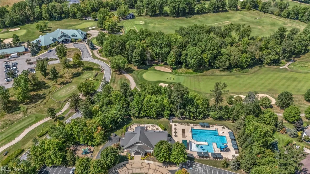 Aerial view of property's location featuring a pool area and a golf course