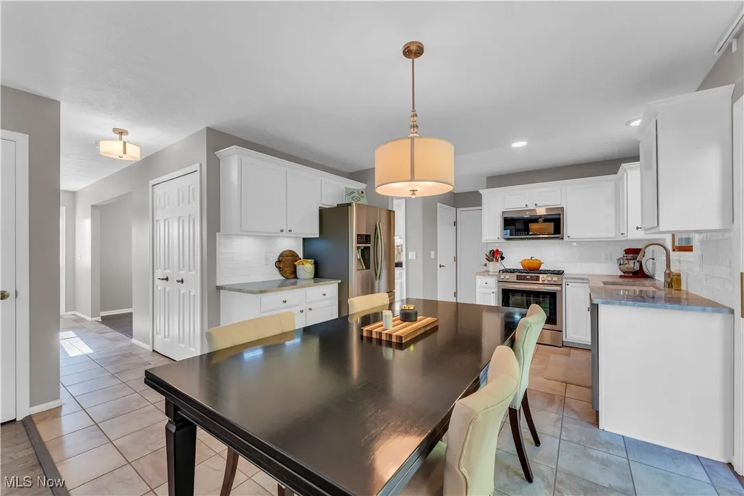 Dining room featuring light tile patterned flooring and recessed lighting