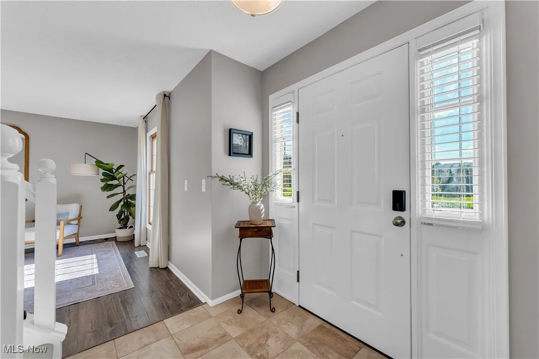Foyer entrance with baseboards and light tile patterned floors