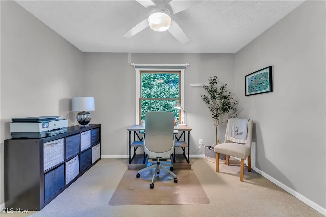 Office area featuring light carpet and ceiling fan