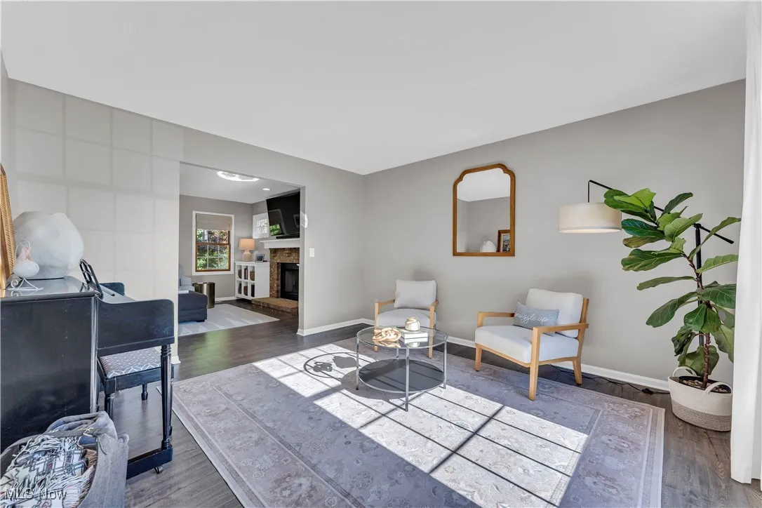 Sitting room featuring wood finished floors and a glass covered fireplace
