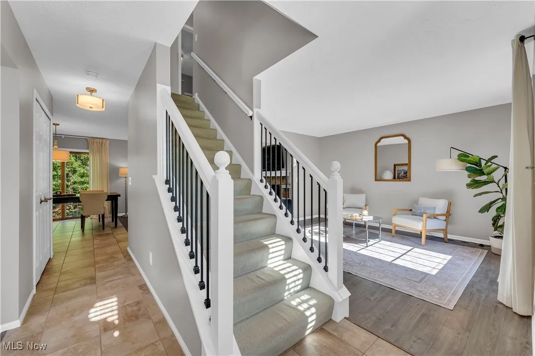 Stairway with baseboards and tile patterned flooring