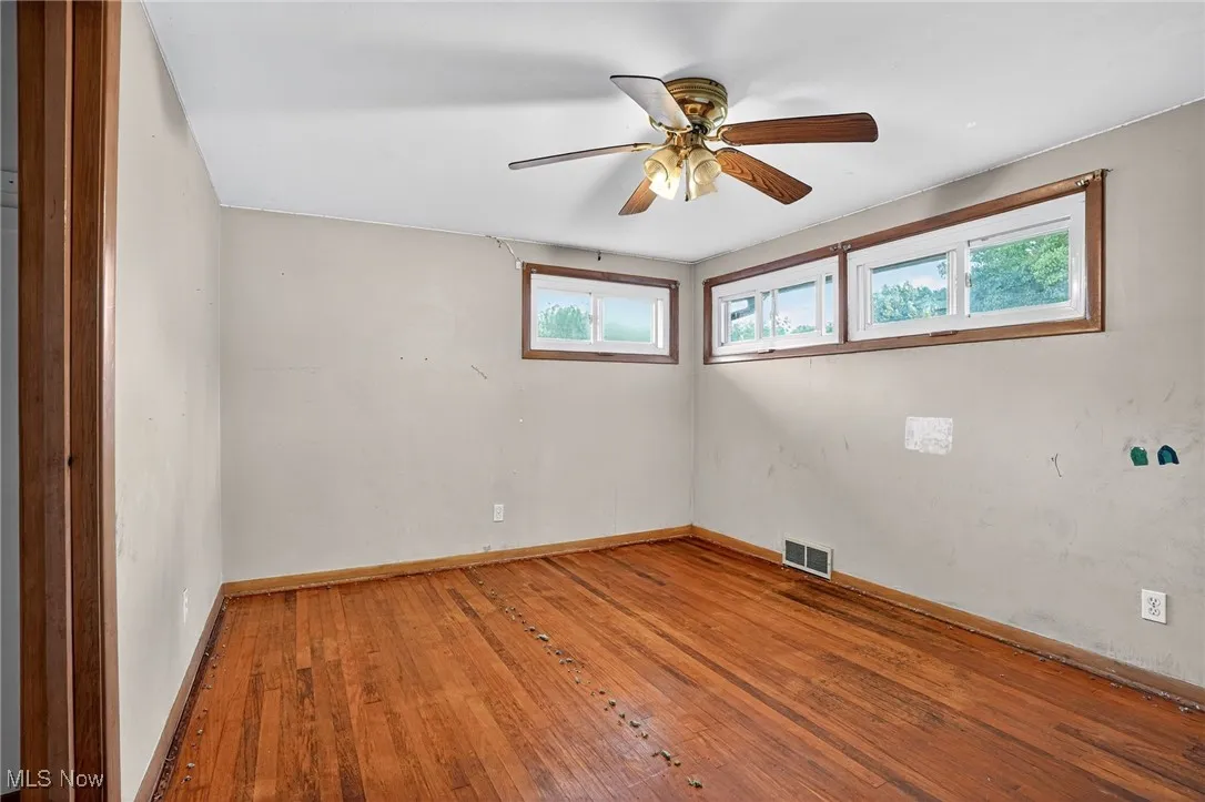 Unfurnished room with hardwood / wood-style floors and ceiling fan