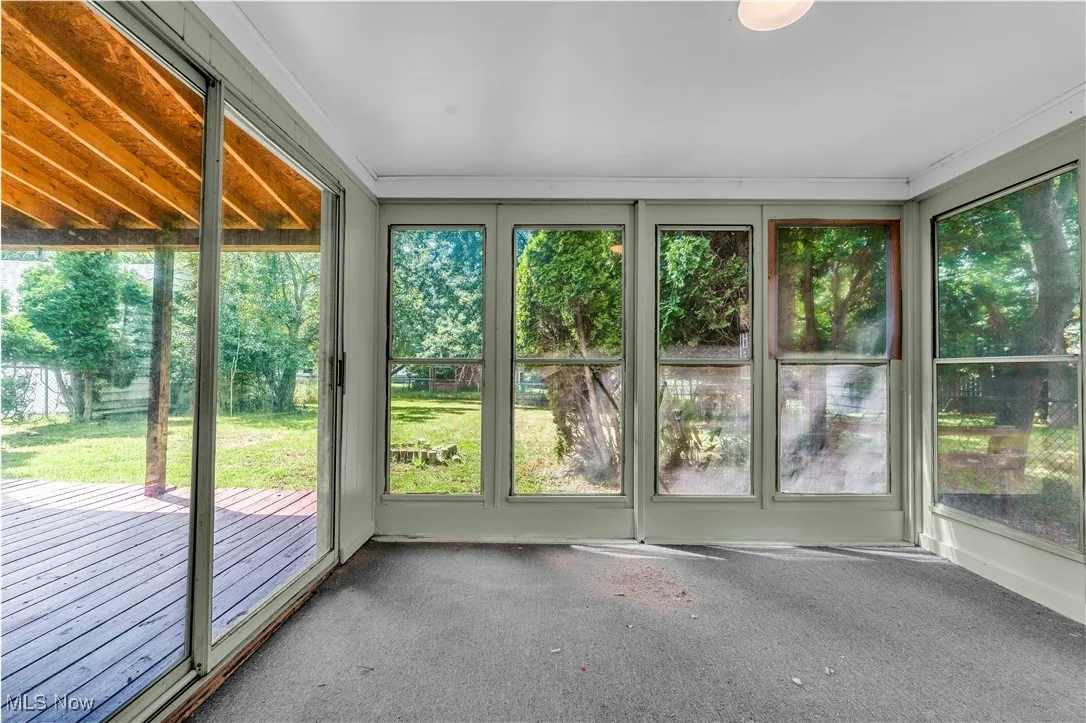 Unfurnished sunroom featuring carpet