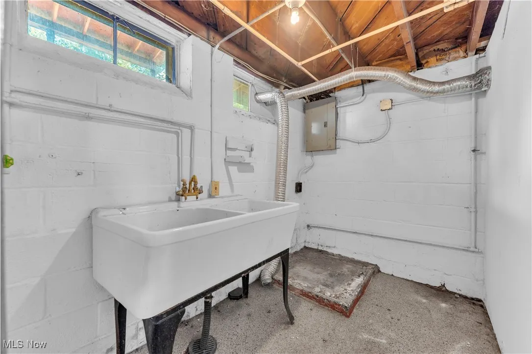 Below grade area with a sink and electric panel