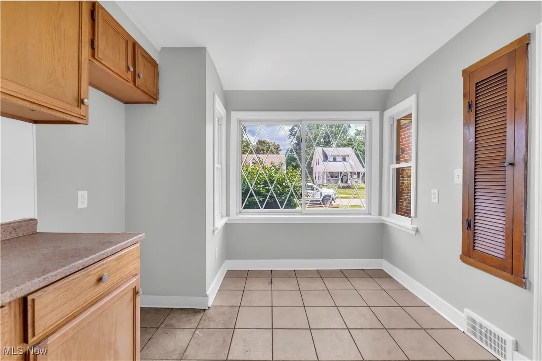 Kitchen with light tile patterned floors and baseboards