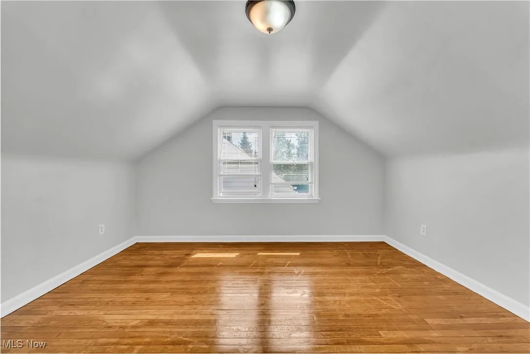 Bonus room featuring light wood finished floors and lofted ceiling