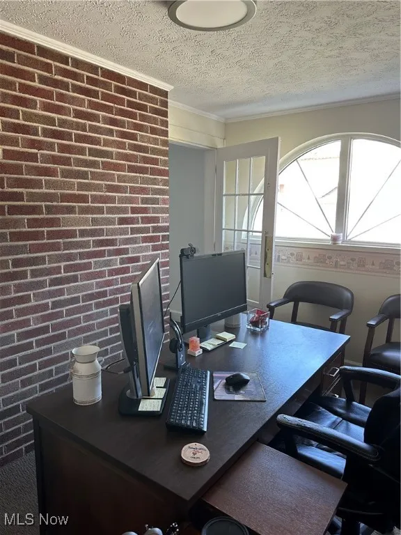 Private Office featuring brick wall, a textured ceiling, and crown molding