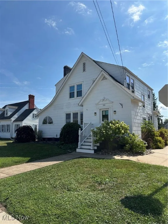 Front of property with lawn and a chimney