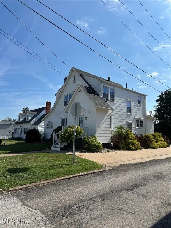 View of side of property with a yard and additional parking