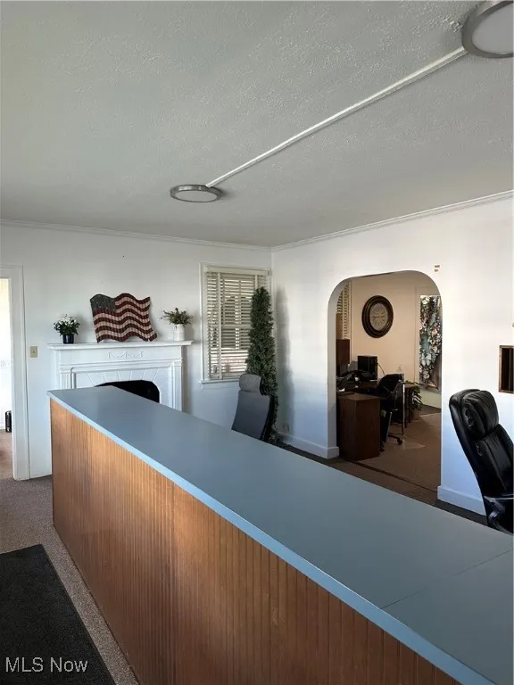 Reception/ lobby area featuring arched walkways, a textured ceiling, and a fireplace