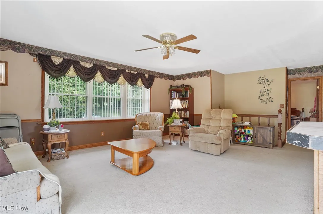 Living area with carpet flooring and a ceiling fan