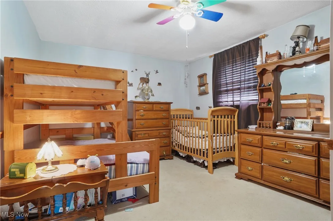 Bedroom with light colored carpet and ceiling fan