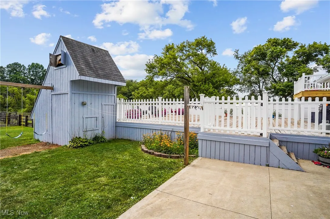 View of yard featuring a wooden deck and a shed