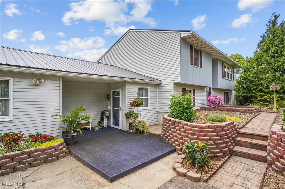 Doorway to property featuring a patio and a metal roof