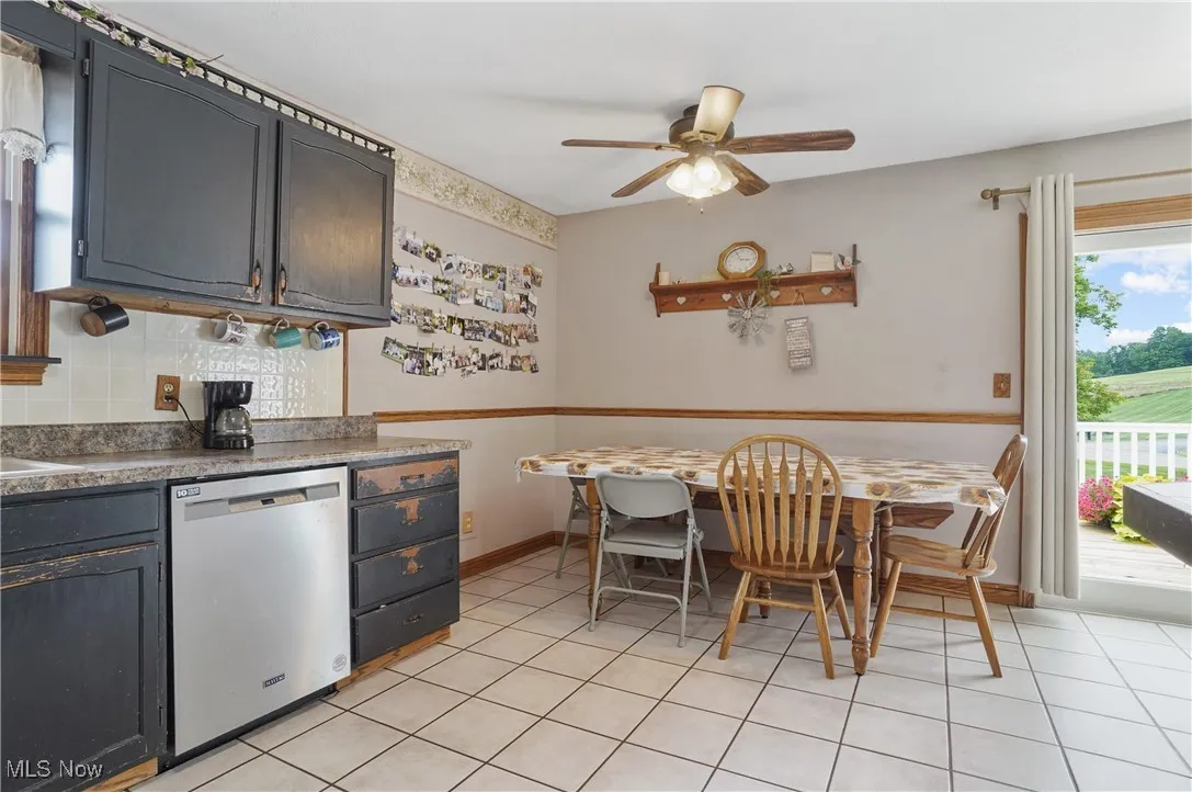 Kitchen with dishwasher, light tile patterned floors, tasteful backsplash, and a ceiling fan