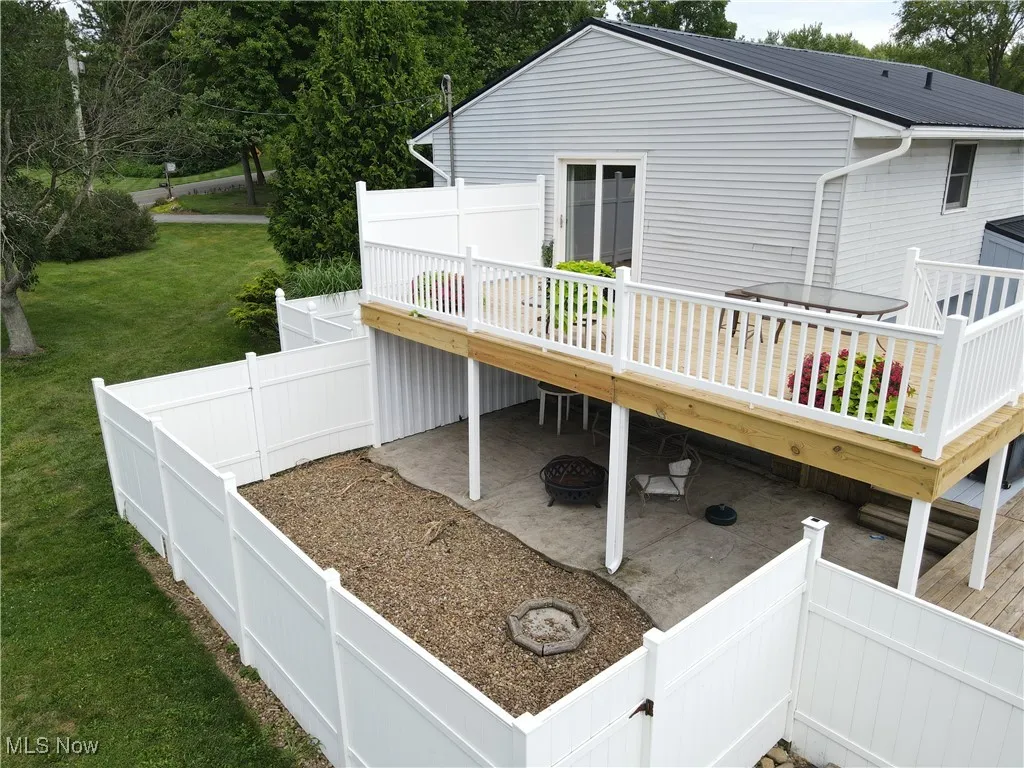 Wooden terrace with a fenced backyard and a patio