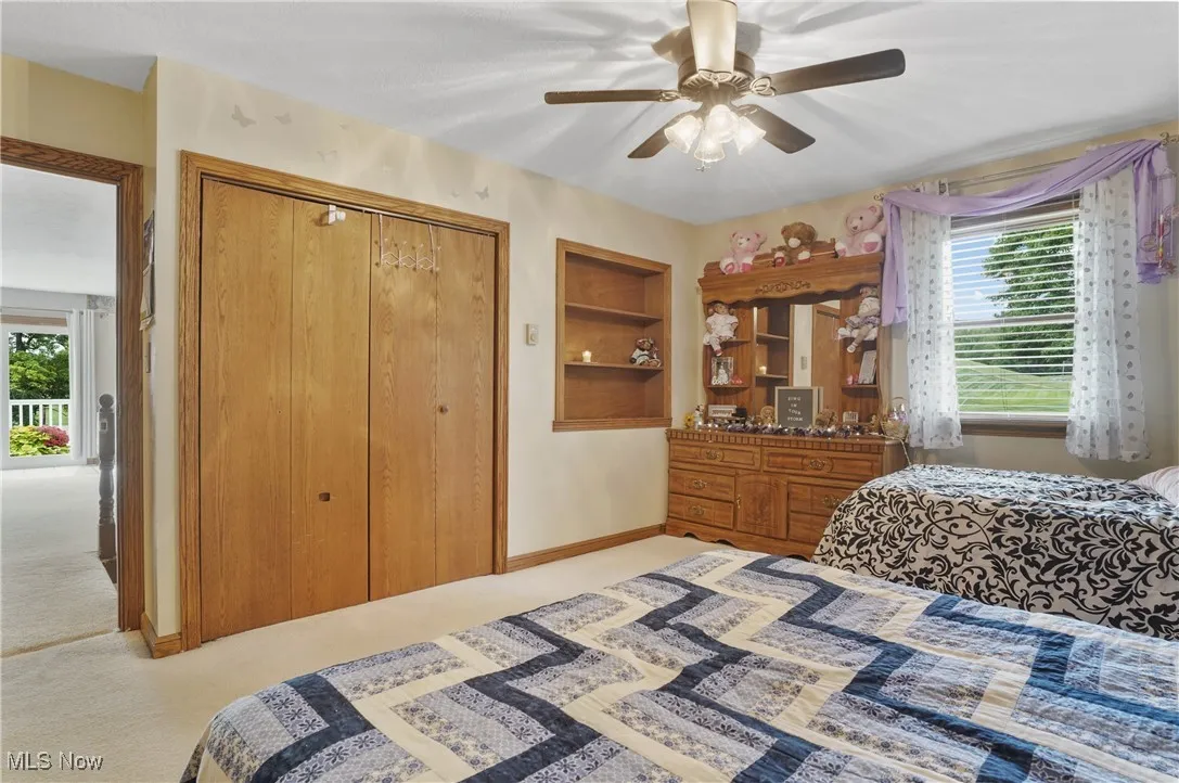 Bedroom featuring a closet, light colored carpet, and ceiling fan