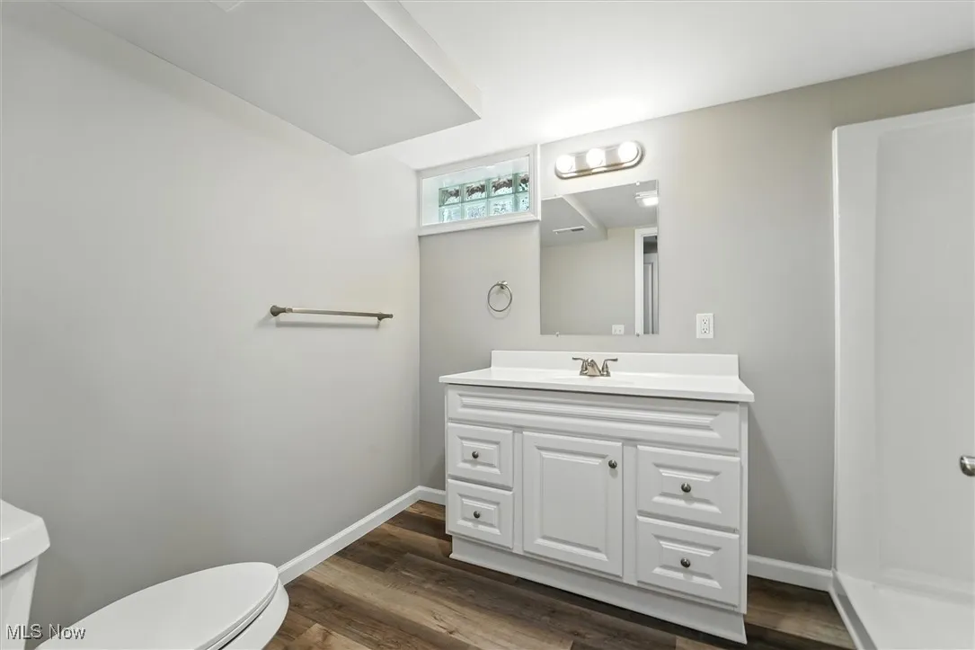 Half bath with vanity and dark wood finished floors