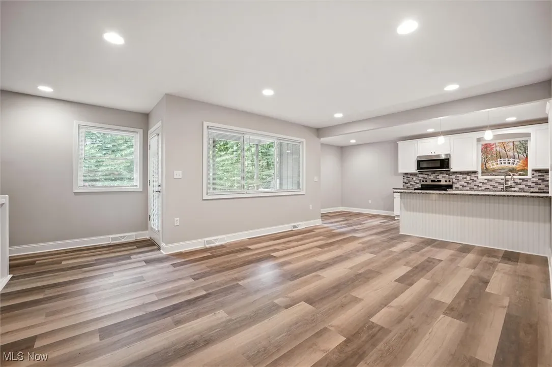 Unfurnished living room with recessed lighting, plenty of natural light, and light wood-style flooring