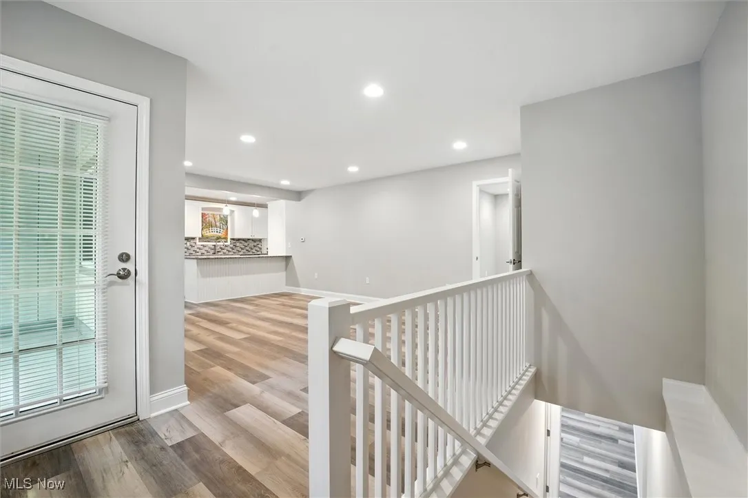 Stairway featuring wood finished floors and recessed lighting