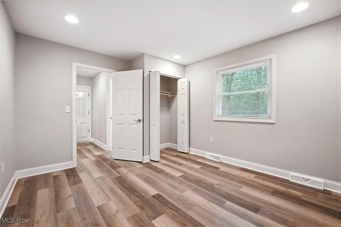 Unfurnished bedroom with light wood-style floors, recessed lighting, and a closet