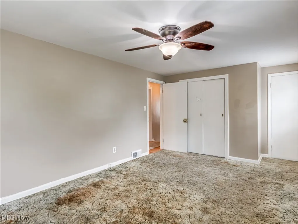 Unfurnished bedroom featuring carpet, a closet, and ceiling fan