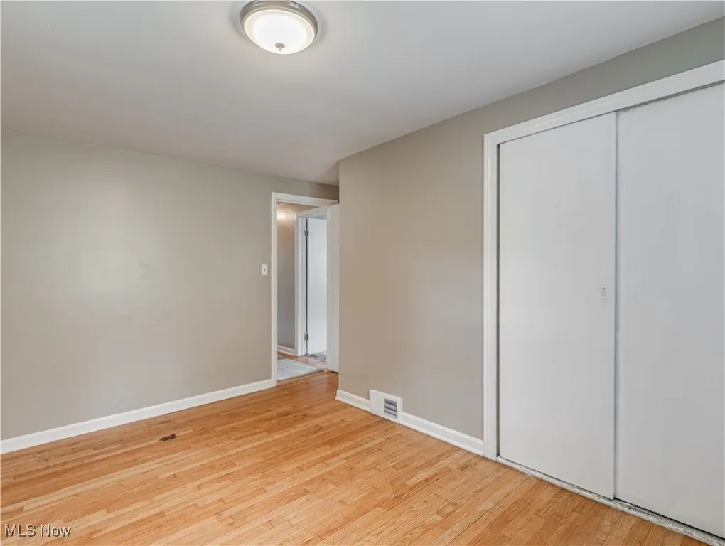 Unfurnished bedroom featuring light wood-style flooring and a closet
