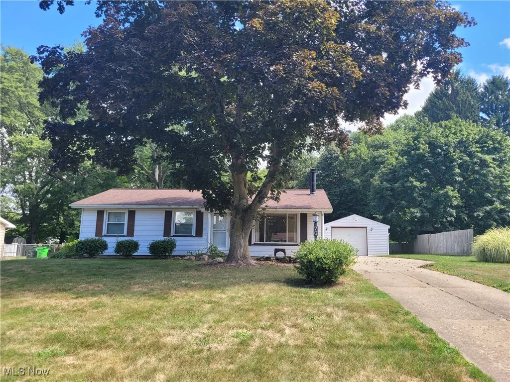 View of front of house featuring concrete driveway and an outbuilding