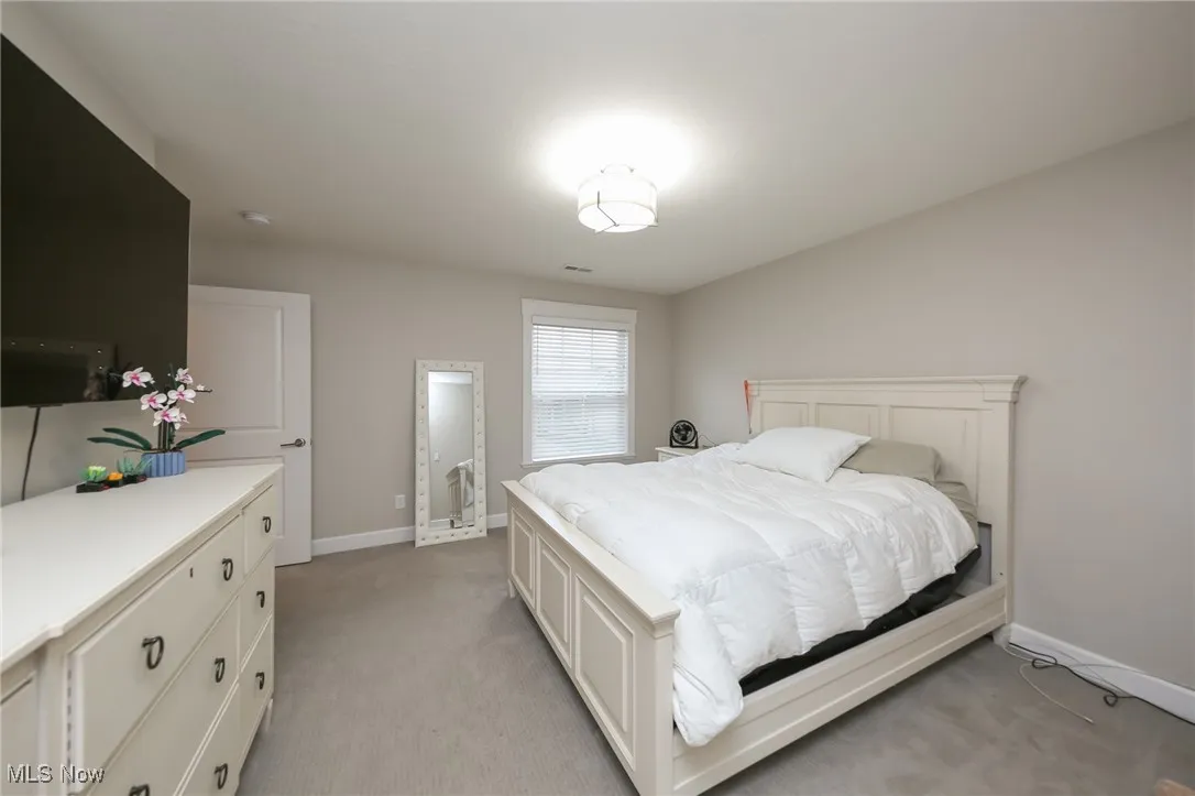 Bedroom with baseboards and light carpet