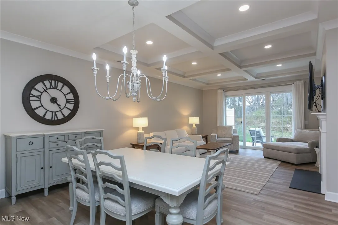 Dining area featuring light wood finished floors, beamed ceiling, coffered ceiling, recessed lighting, and crown molding