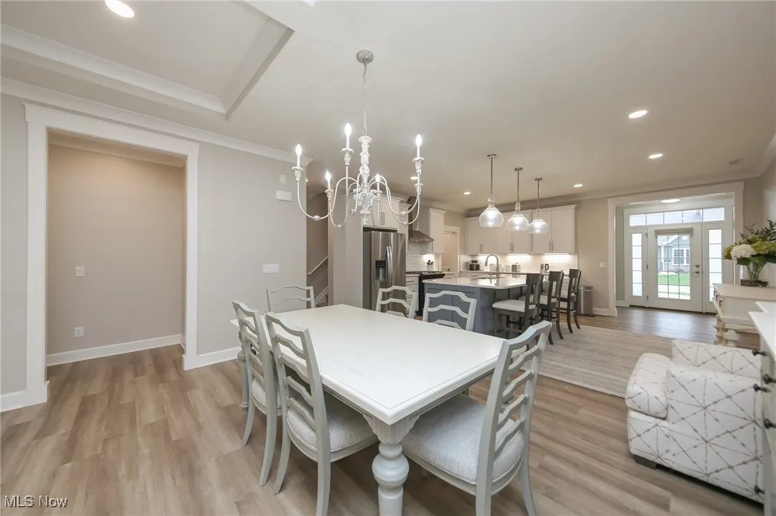Dining room featuring recessed lighting, a chandelier, light wood-type flooring, and crown molding