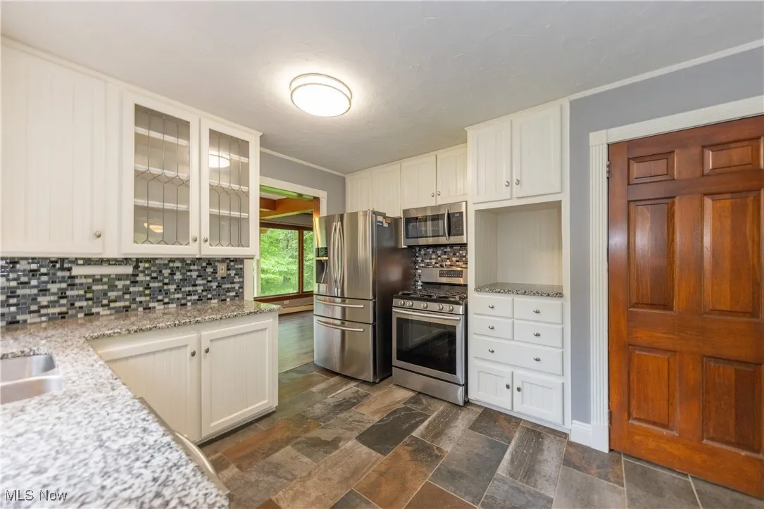 The kitchen features granite countertops and stainless-steel appliances