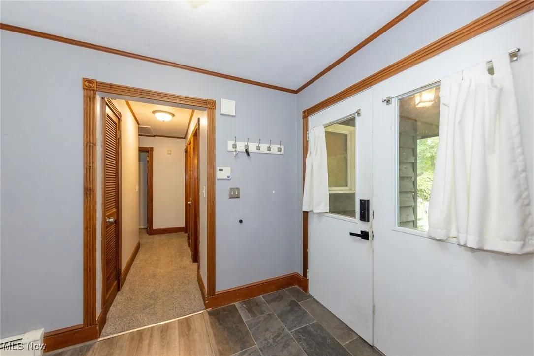 Front entrance with a view of the hallway leading to 3 bedrooms on the first floor and a full hall bathroom