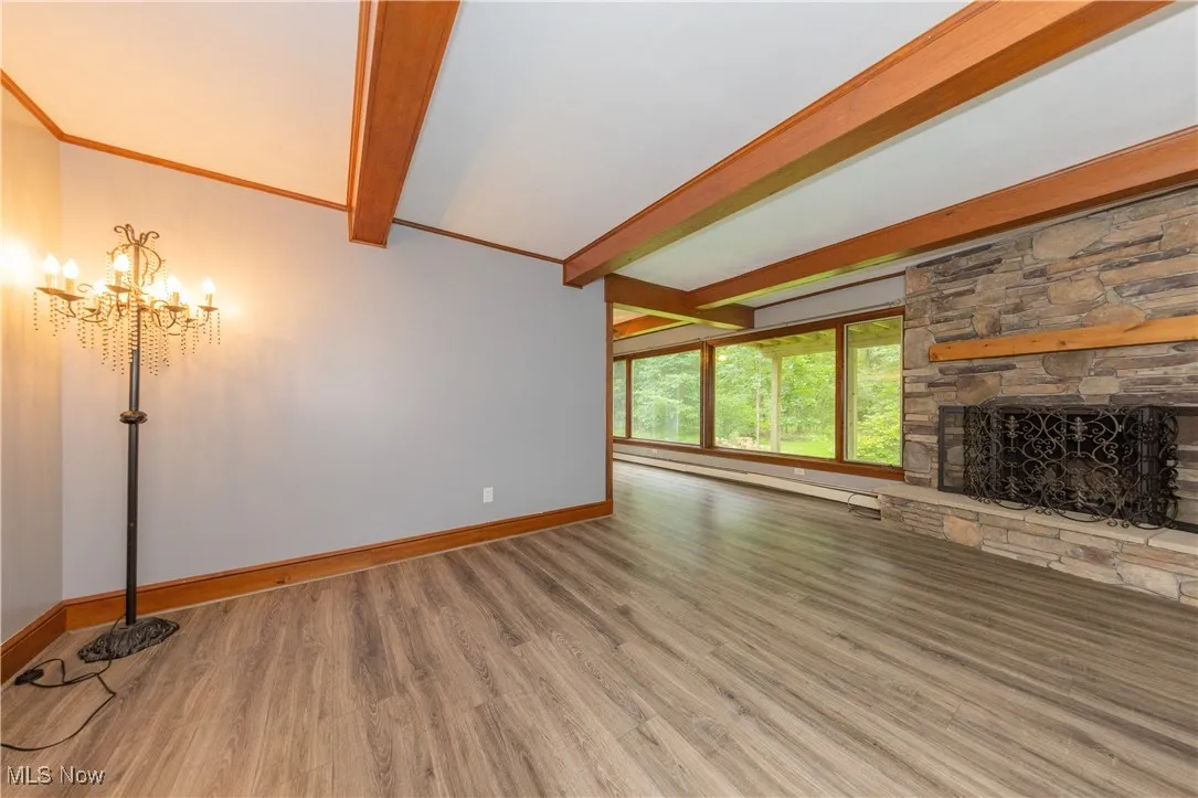 The family room featuring a stone fireplace and beamed ceilings