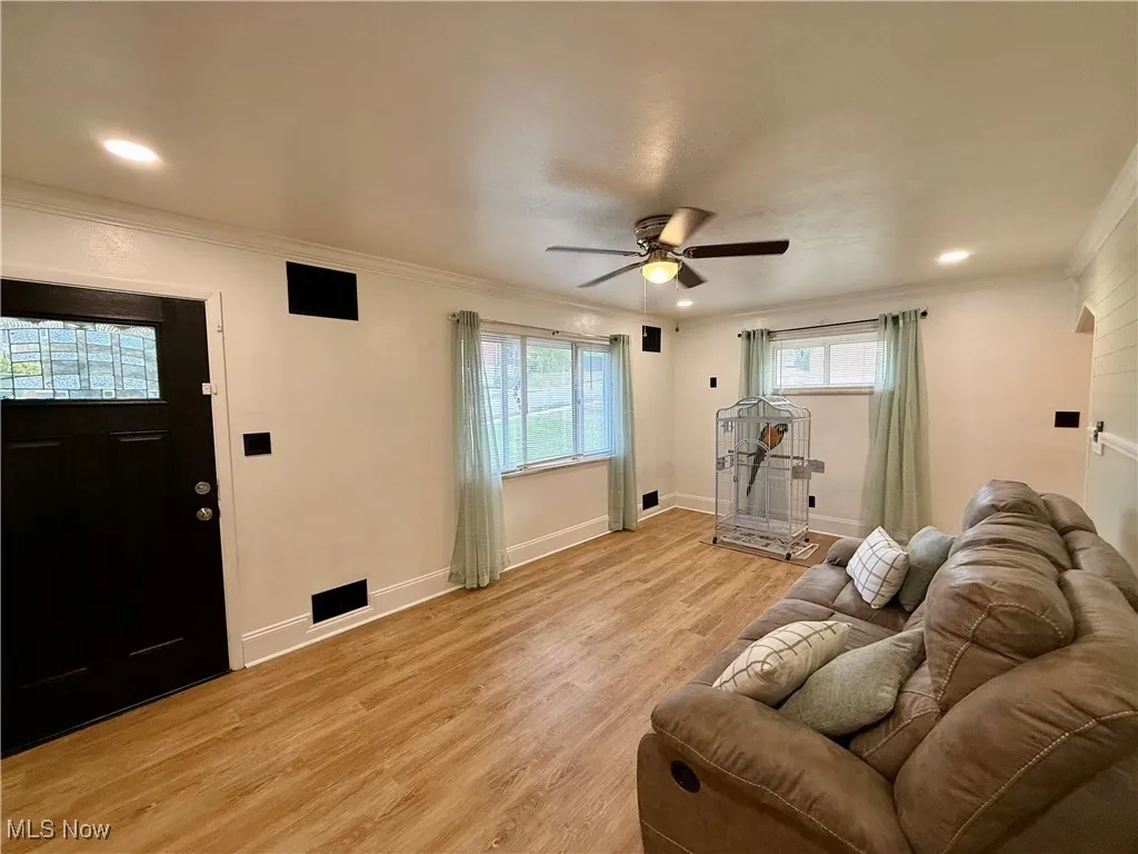 Living room with light wood-style floors, ornamental molding, a ceiling fan, and recessed lighting