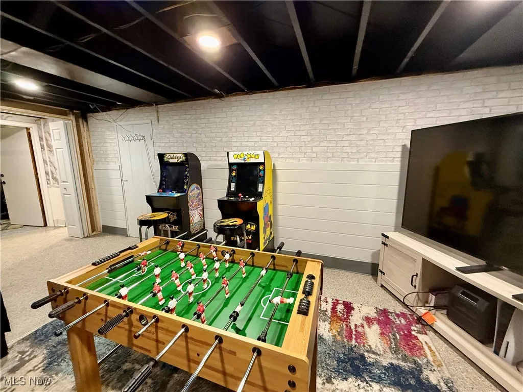 Rec room featuring brick wall and carpet