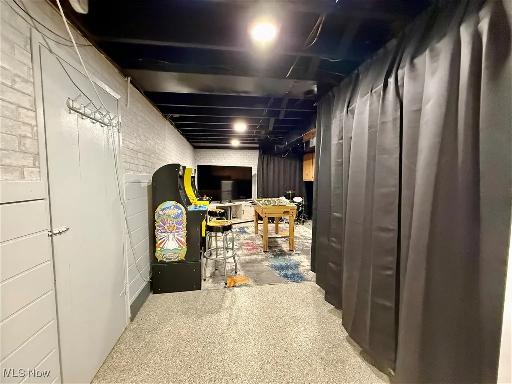 Unfinished below grade area featuring brick wall