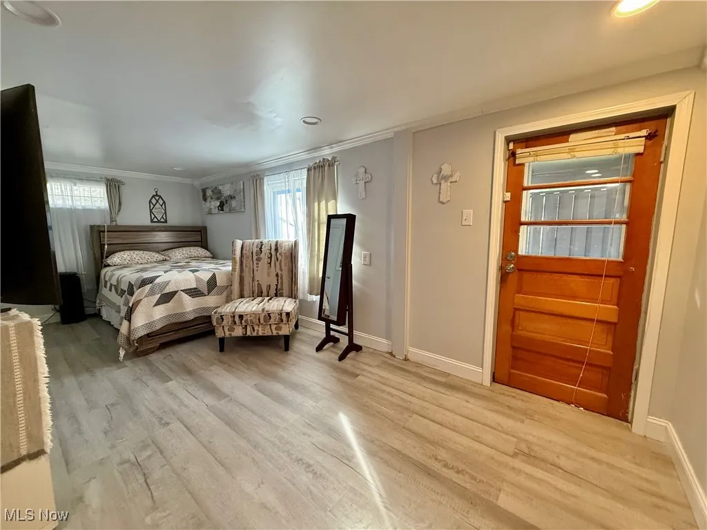 Bedroom featuring wood finished floors, ornamental molding, and recessed lighting